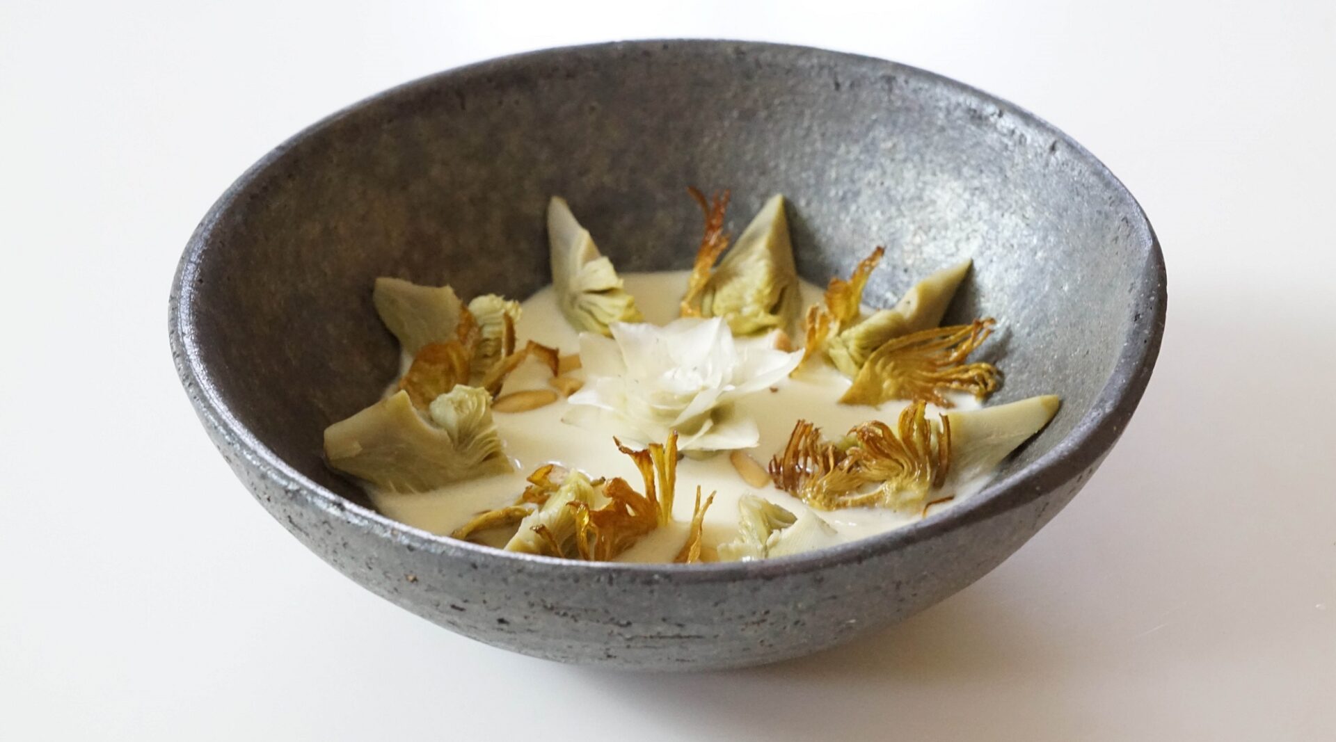 Receta de velouté de alcachofa, con flor de alcachofa, piñones y queso  Galmesano